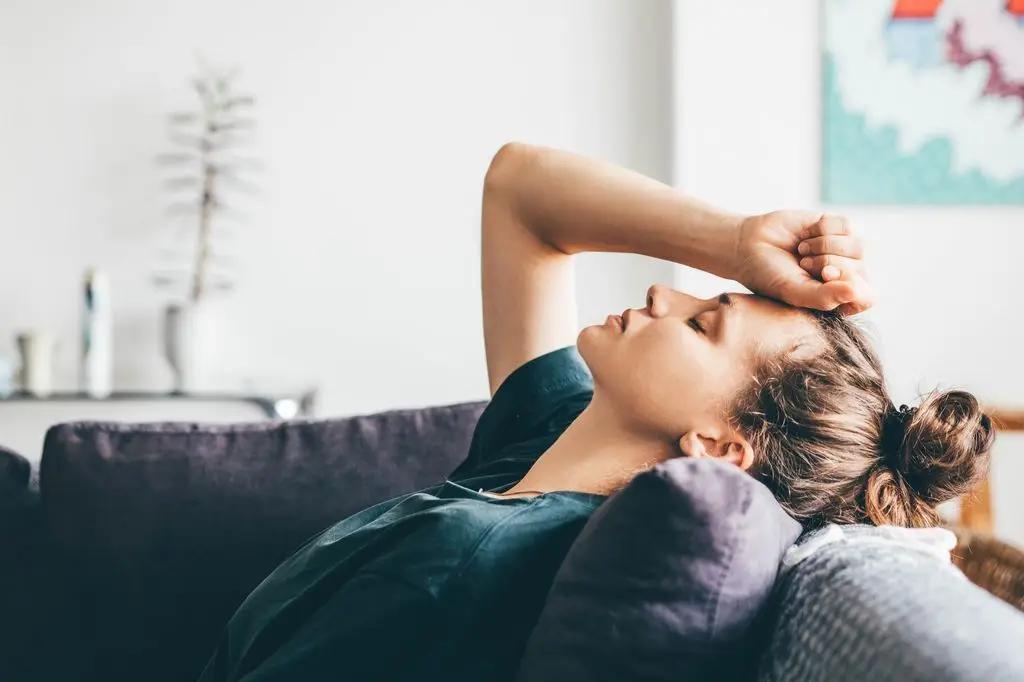 Woman sitting alone looking tired and emotionally drained, reflecting on the quiet exhaustion of a difficult relationship