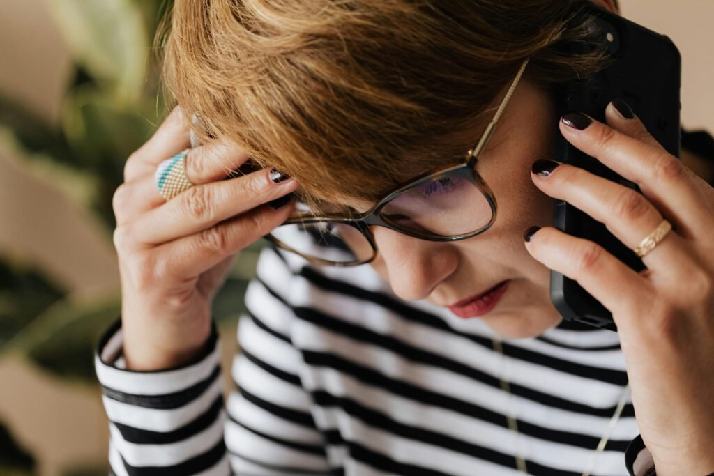 A woman looking overwhelmed on the phone.
