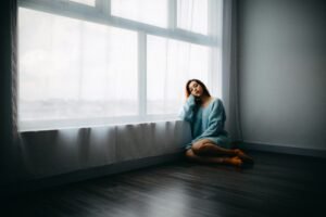 A woman sitting alone near a window,